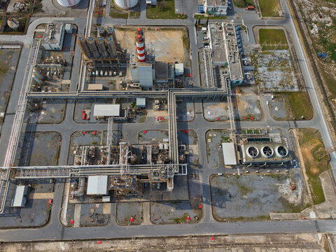 Aerial view of an industrial complex with a red and white striped tower amidst a network of pipes and structures, Thessaloniki, Thessaloniki, Greece.