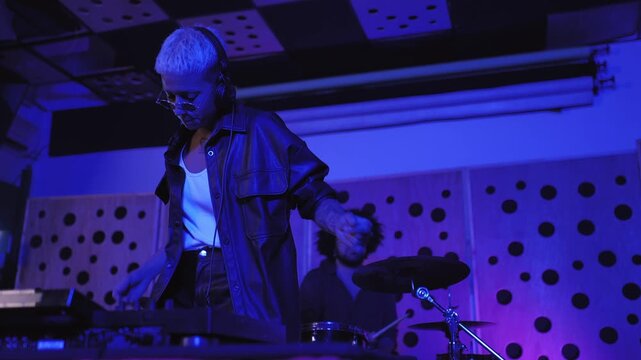Multiracial people record music inside studio - DJ and drum player having fun during concert 