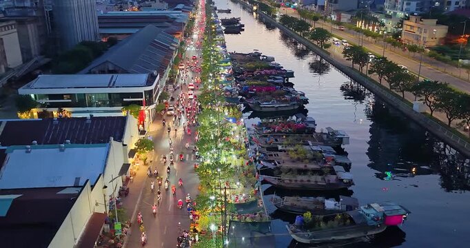 Aerial view of Binh Dong flower market wharf in Ho Chi Minh city, Vietnam during Tet Holiday season. Boats loaded with colorful flowers line the canal, creating a unique floating market atmosphere
