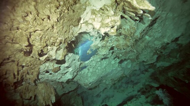A visible air pocket forms beneath a ceiling of stalactites inside a submerged limestone cavern in Cenote Dos Ojos, Quintana Roo