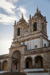 Fototapeta premium Historic Stone Church with Bell Towers Against Blue Sky