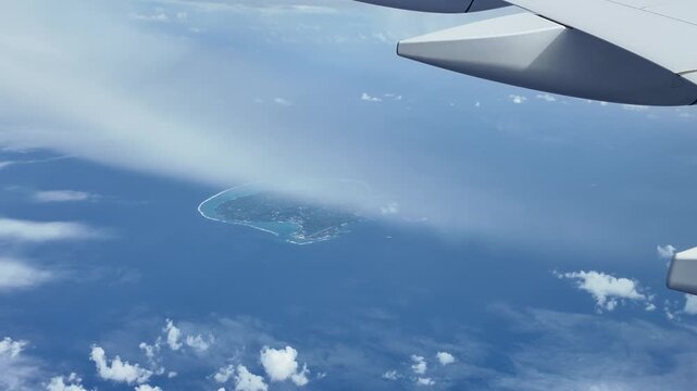 機窓から見下ろす与論島の全景とヨロンブルーの絶景 百合ヶ浜のサンゴ礁と与論空港 空撮 動画素材 4K