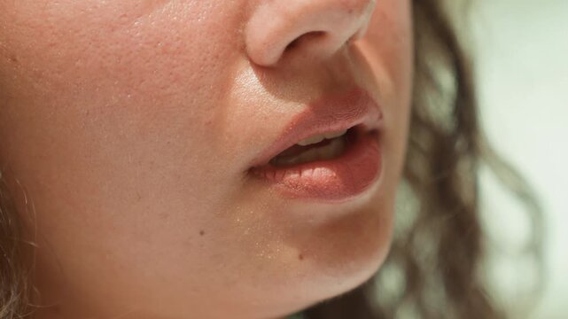 Calm glowing face. Relaxed mouth illuminated softly by tranquil soothing luminous surroundings. Closeup image of serene lips softly glowing under gentle peaceful and calming light effects