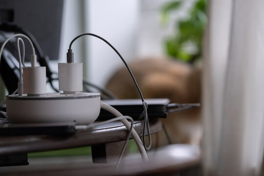 Charging cables and power adapters on table, modern technology lifestyle concept