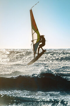 Cascais, Portugal - 28 March 2026: View of a windsurfer silhouetted against massive crashing waves at Praia do Guincho with white sea foam and deep blue water.