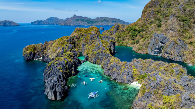 Aerial view of a beautiful tropical island with crystal clear water with limestone cliffs as the beach, Coron, Palawan, Philippines.