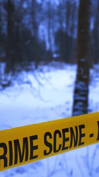 Crime scene tape cordoning off a snowy forest during winter snowfall