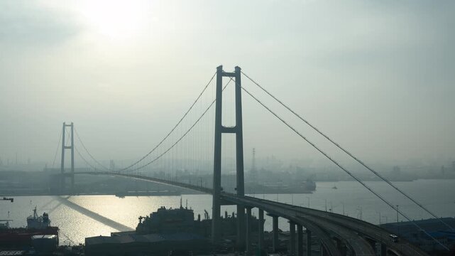 Sunset timelapse of Ulsan Bridge with shipyard and industrial complex in smog