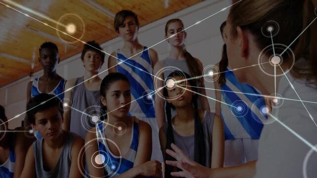 Coach gesturing at sports team in gym, generating HUD network supporting tactics linking players