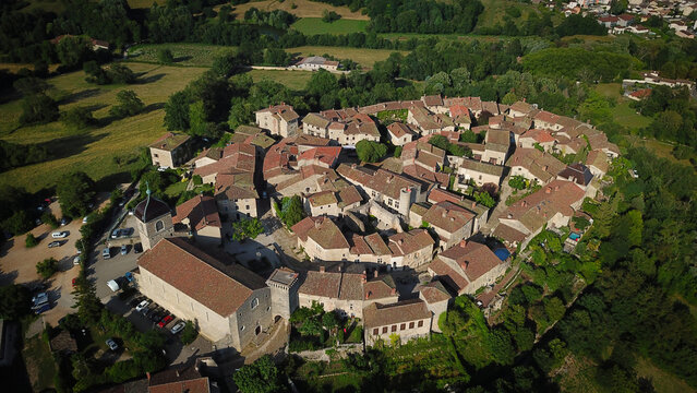 Aerial view of the fortified medieval village with its red-tiled roofs and stone buildings nestled amid the lush green landscape, Perouges, Auvergne-Rhone-Alpes, France.
