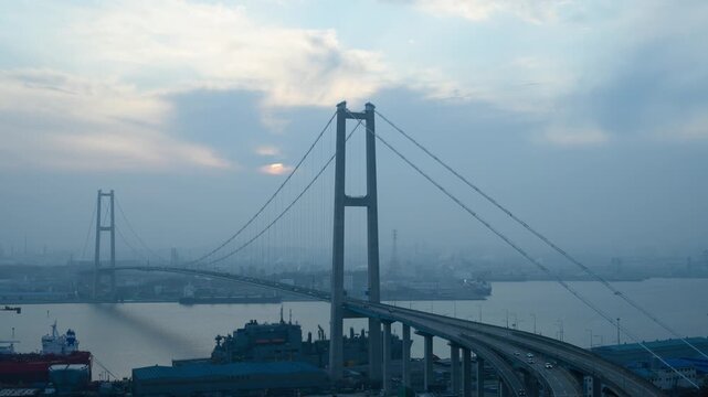 Sunset timelapse of Ulsan Bridge with shipyard and industrial complex in smog