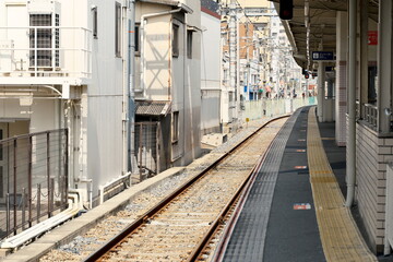 Fototapeta premium 鉄道駅のホーム縁と線路のクローズアップ 公共交通インフラ、通勤の日常、安全と境界線を象徴するコンセプトイメージ
