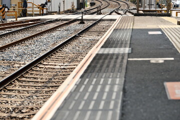 Naklejka premium 鉄道駅のホーム縁と線路のクローズアップ 公共交通インフラ、通勤の日常、安全と境界線を象徴するコンセプトイメージ