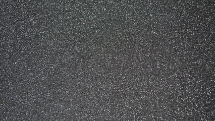 Fototapeta premium Textured black surface with fine glitter particles creating a shimmering effect
