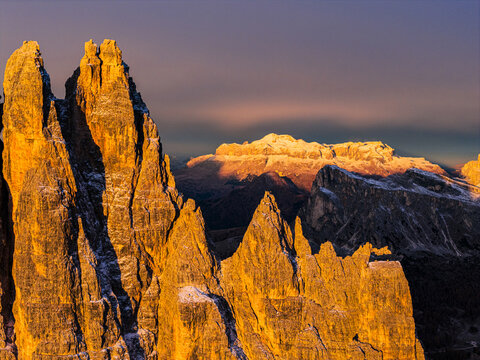 Aerial view of jagged peak Croda da Lago, with the warm hues of the Enrosadira, in the background Sellaa-Pordoi range, Dolomites, Italy.