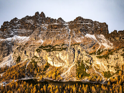 Aerial view of rugged Croda da Lago layered with snow and bathed in golden light. Federa, Cortina d'Ampezzo, Veneto, Italy.