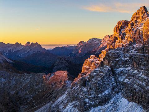 Aerial view of rugged, sun-kissed Cima di Ambrizzola peak, pierce the skyline as shadows dance in the valleys, showcasing nature's grandeur, Cortina d'Ampezzo, Veneto, Italy.