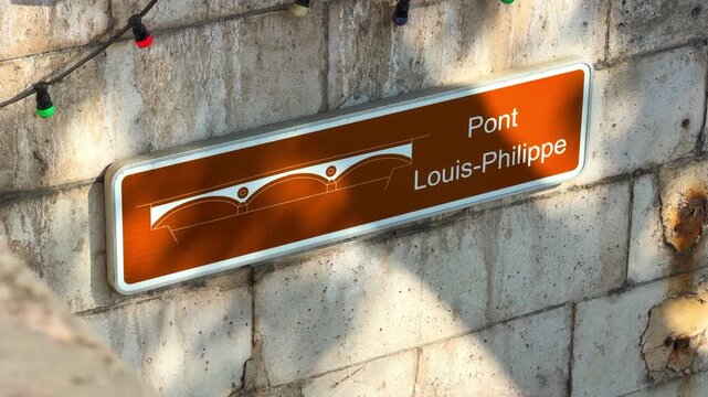 Pont Louis-Philippe sign on the stone wall of the famous bridge in Paris, France