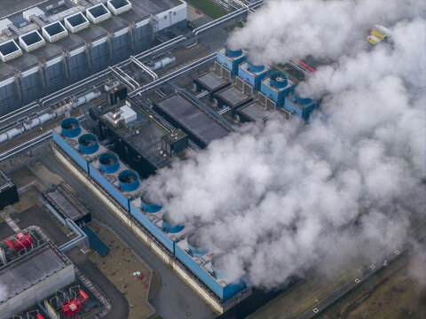 Aerial view of data center showing multiple industrial cooling towers releasing steam at a server facility in eemshaven