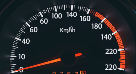 Fototapeta premium Close-up of Modern Car Speedometer with km/h Scale and Red Needle on Black Dashboard