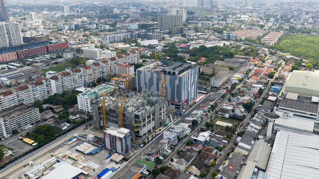 Aerial view of STT Bangkok 1 data center under construction with yellow cranes and surrounding urban residential buildings Krung Thep Maha Nakho, Thailand.