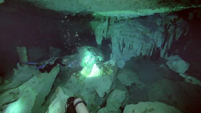 Massive column connects floor and ceiling surrounded by cave walls in Cenote Dos Ojos, Quintana Roo, Mexico