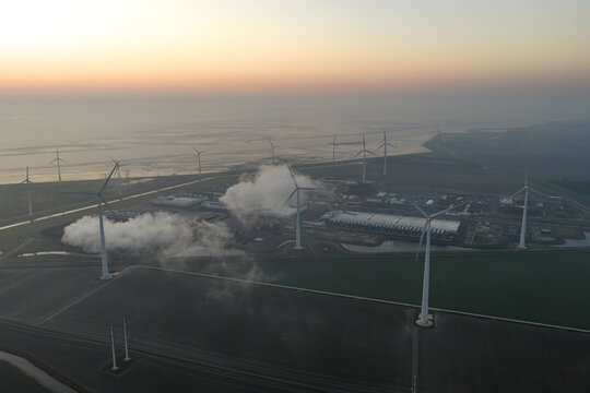 Aerial view of hyperscale data center complex with wind turbines at sunset