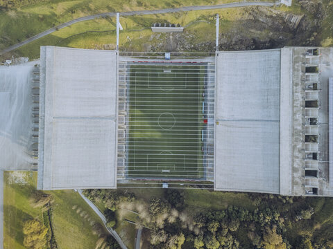 Aerial view of the imposing Braga Municipal Stadium nestled between rocky hills, its concrete structure contrasting with the verdant field, Braga, Braga, Portugal.