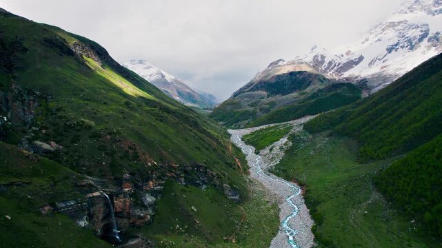 4K Aerial shot of beautiful landscape of Indian Himalayas. Chabi waterfall and Chenab river flowing in mountains at Sural Bhatori, Pangi Valley, India. Summer season in mountains. Traveling concept ba