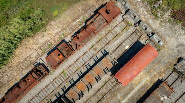 Aerial view of rusted train engines and carriages sit silently on parallel tracks, a testament to time's passage, Vila Nova de Gaia, Portugal.