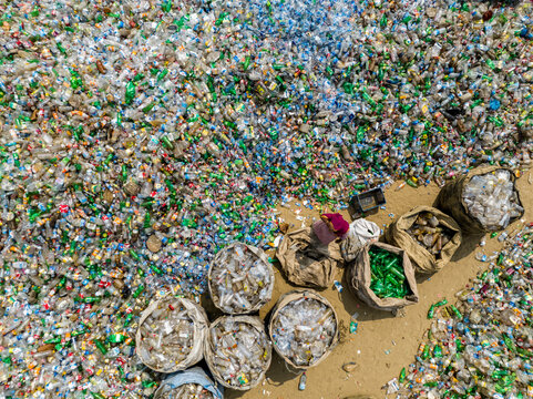 Aerial view of a sprawling landscape of discarded bottles and recyclables, a stark contrast of colors and textures, a reminder of environmental challenges, Chattogram, Bangladesh.