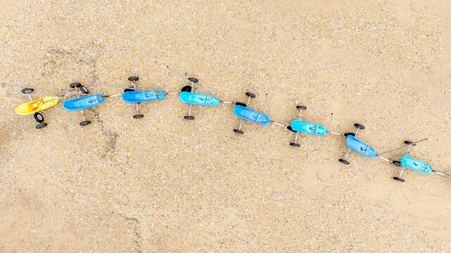 Aerial view of a line of colorful toy cars stretching across the sandy ground, Fort-Mahon-Plage, Hauts-de-France, France.
