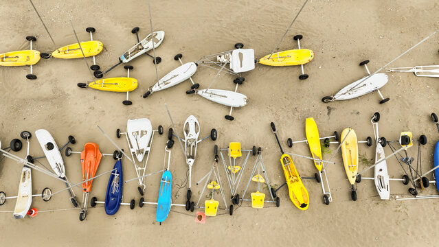 Aerial view of colourful sand yachts scattered across the sandy beach, Fort-Mahon-Plage, Hauts-de-France, France.