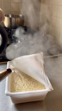 インスタント焼きそばを作るために、やかんのお湯を入れる人