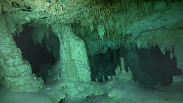 Vertical limestone columns formed by stalactites and stalagmites inside cave in Cenote Dos Ojos, Quintana Roo, Mexico