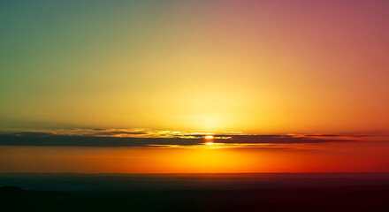 Obraz premium Vibrant Sunset Over Calm Water Reflecting Fiery Hues.