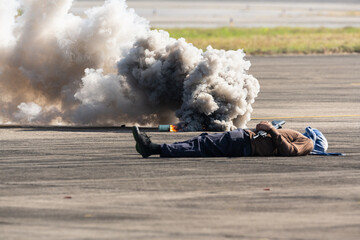 Obraz premium Selective smoke from smoke bomb and out of focus terrorist lies dead during military assault drill.The criminal was killed by riot police.A drill simulating a rescue operation against terrorists