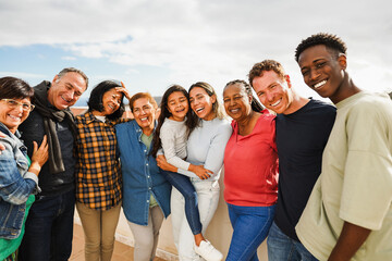 Group of multigenerational friends smiling in front of camera - Multiracial people of different...