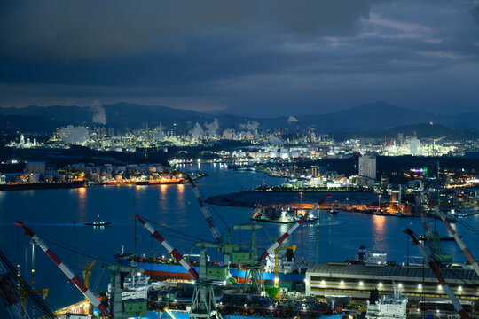 Ulsan Industrial Complex Skyline. Oil Refineries, Petrochemical Plants, Shipyard Cranes and Taehwa River at Sunset with Dramatic Clouds