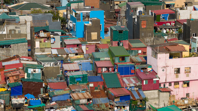 Aerial view of densely packed colorful houses and informal settlements with corrugated metal roofs in Navotas, Metro Manila, Philippines.