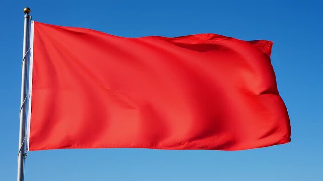 Red flag waving on silver pole.