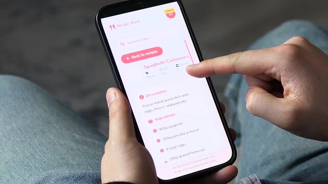 Close-up of a person choosing a Spaghetti Carbonara recipe on a mobile cooking app. User reviews ingredients and difficulty level for meal prep. Perfect for lifestyle, culinary, and healthy eating