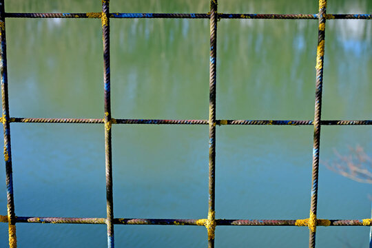 odd grid of a fence with a lake in the background