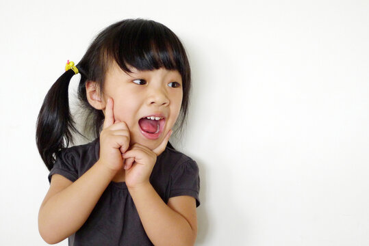 Close-up portrait of a young Girl with a surprised expression and her hands on her face