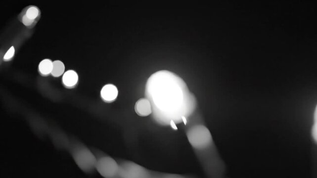 Black and white close up of tiny string lights with smoke swirling around, bokeh effect, creating a dreamy, minimalist aesthetic