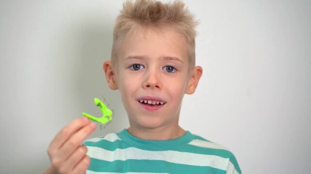 Dentist test setting of palatal braces for young patient in child's hand. Jaw correction