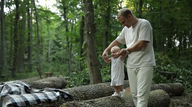 Baby girl learning to walk with parents in forest