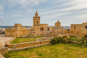 Fototapeta premium Citadel in Rabat, Gozo, Malta, on a sunny day, featuring historic stone walls, ancient architecture, and panoramic views over the island under bright Mediterranean skies.