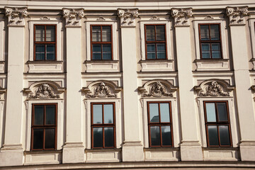 Obraz premium Elegant European facade with decorative window details in Vienna. Ideal for architecture, travel, heritage, and urban design concepts.