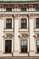 Obraz premium Close-up of a historic Vienna facade featuring sculpted faces and decorative baroque elements. Ideal for heritage, art, and architectural detail concepts.